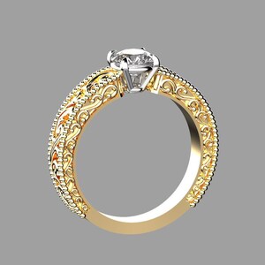 May include: A gold ring with a large, clear gemstone. The band features intricate filigree and beaded detailing. The ring is set against a gray background, highlighting its ornate design and the brilliance of the central stone.