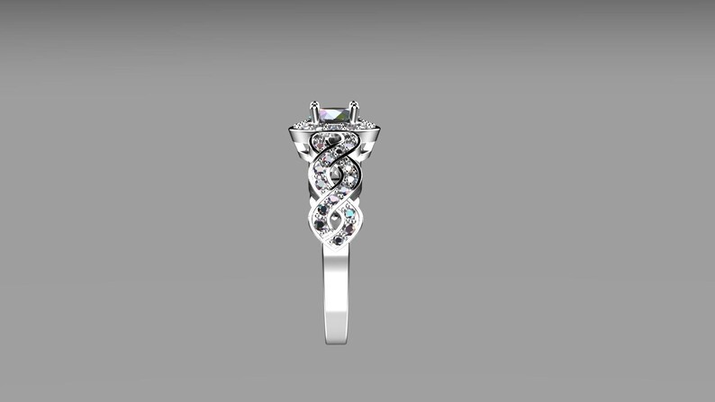May include: A silver engagement ring with a square-shaped center stone surrounded by smaller stones. The band is intricately designed with a braided pattern and set with smaller stones.