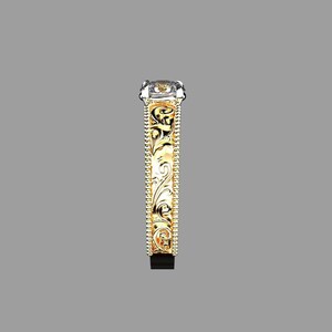 May include: A side view of a gold and silver ring with an ornate, engraved design. The ring features a rectangular, clear gemstone and a detailed pattern along the band. The ring's design includes a gold band with intricate floral patterns.