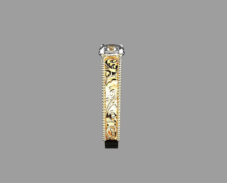 May include: A side view of a gold and silver ring with an ornate, engraved design. The ring features a rectangular, clear gemstone and a detailed pattern along the band. The ring's design includes a gold band with intricate floral patterns.