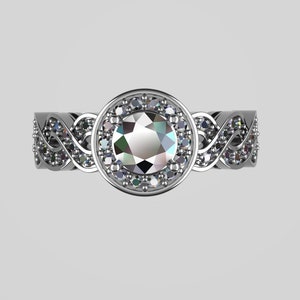 May include: A silver ring with a large, round, clear gemstone surrounded by smaller, clear gemstones. The band of the ring is intricately designed with a braided pattern.