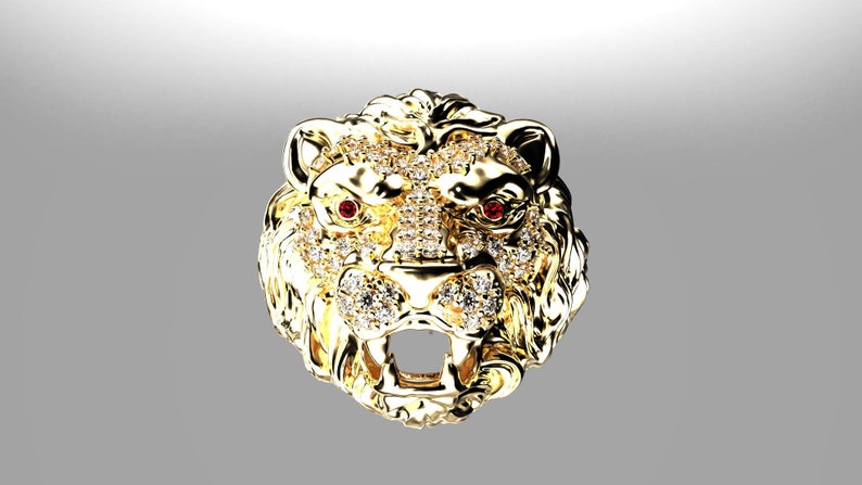 May include: A gold lion head pendant with red gemstone eyes and a detailed design. The pendant is covered in small, clear stones.