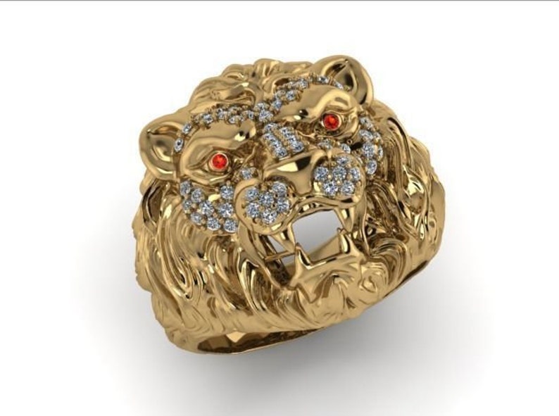 May include: A gold lion head ring with red eyes and a diamond-encrusted mane.