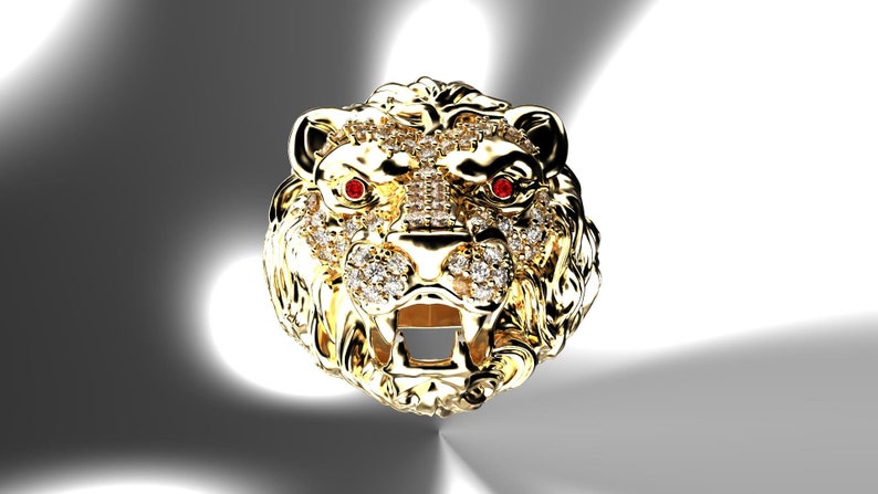 May include: A gold lion head ring with red ruby eyes and a diamond-encrusted design.