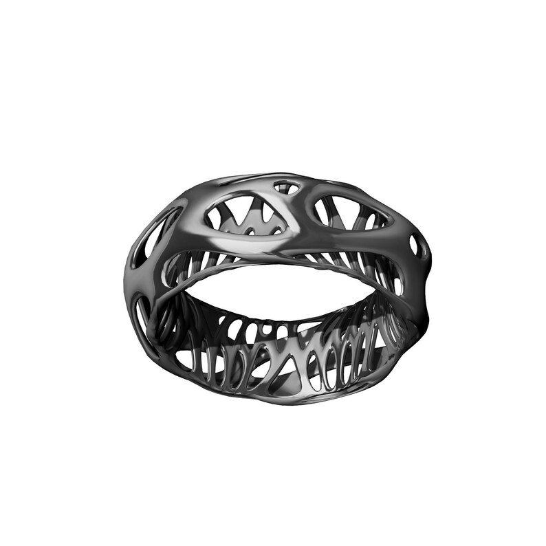 May include: A black, openwork ring with a geometric design. The ring is made of a smooth, shiny metal.