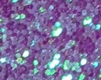 Op de afbeelding: Paarse glitter met iriserende blauwe en groene vlekken. De glitter is fijn en creëert een glinsterend effect.
