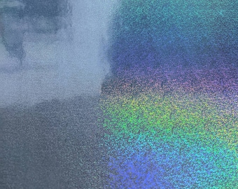 Op de afbeelding: Een close-up van een holografisch, iriserend oppervlak met een textuur, een glinsterende afwerking. Het oppervlak is een gradiënt van kleuren, waaronder blauw, groen en paars.