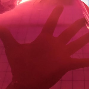 May include: A sheet of bright pink vinyl with a glossy finish.