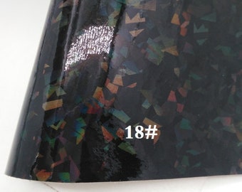 May include: Black vinyl with a holographic finish featuring a confetti pattern in shades of gold, silver, red, blue, and green. The vinyl has the number 18# printed on it.