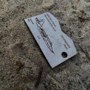 Token of Russian airplane made of burned amor Cy 25 recycled in Ukraine