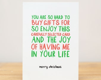 May include: A humorous Christmas card with green and red text that reads "You are so hard to buy gifts for so enjoy this carefully selected card and the joy of having me in your life. Merry Christmas."