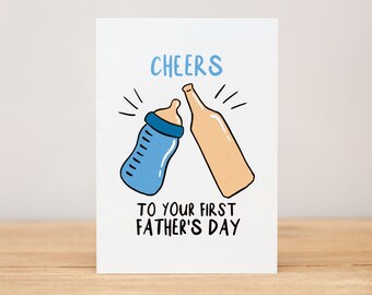 May include: A white card with a blue baby bottle and a brown beer bottle clinking together. The text on the card reads "CHEERS TO YOUR FIRST FATHER'S DAY".