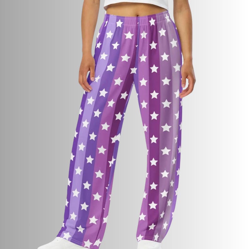 Puede incluir: Pantalones de pijama con estampado de estrellas moradas y blancas. Los pantalones presentan rayas verticales de diferentes tonos de morado, cada una adornada con estrellas blancas. Ajuste relajado y c&oacute;modo.