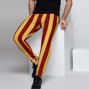 May include: Red and yellow striped sweatpants. The sweatpants are made of a soft, comfortable fabric and have a relaxed fit.