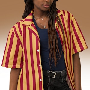 May include: A red and gold striped button-up shirt with short sleeves. The shirt has a relaxed fit and a collar.