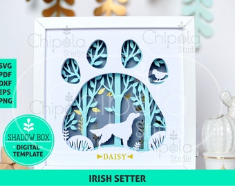 Puede incluir: Una plantilla digital de caja de sombras con marco blanco, con un diseño de huella de pata y una silueta de Setter irlandés. El diseño incluye árboles, un pájaro y el nombre "DAISY". El texto "IRISH SETTER" está en la parte inferior. Disponible en formatos SVG, PDF, DXF, EPS y PNG.