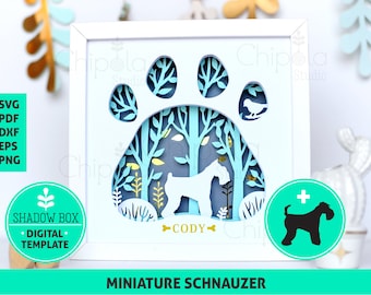 Puede incluir: Una caja de sombra blanca con un diseño de huella de pata azul. La huella de pata tiene una escena de bosque en el interior con una silueta de perro schnauzer miniatura blanco. El perro está etiquetado como "Cody".