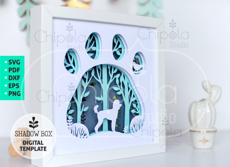 May include: A white shadow box with a paw print design, featuring a poodle silhouette within a forest scene. The layered paper art is framed in white, with the text "SHADOW BOX DIGITAL TEMPLATE" and file type icons on the left.