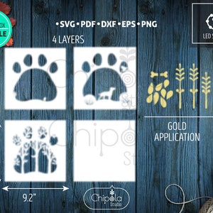 May include: Four layered shadow box cut file design featuring a paw print with a dog and trees inside. The design is 9.2 inches by 9.2 inches and includes a gold application with leaves and branches.