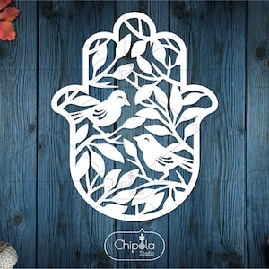 Peut inclure: Découpe de papier blanche d'une main de hamsa avec deux oiseaux et des branches feuillues à l'intérieur. La hamsa est un symbole de protection et de bonne chance.