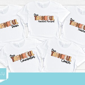 May include: Five white t-shirts with the text "One Thankful" in brown and orange letters. Each shirt has a different job title: Dean, Assistant Principal, Teacher, Counselor, and Coach.