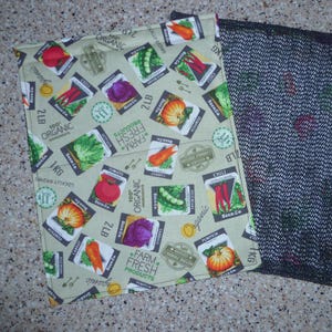 Peut inclure: Deux sacs à provisions réutilisables. L'un est en tissu beige avec un motif de paquets de graines de légumes, dont des tomates, des carottes et des citrouilles. L'autre est un sac en filet noir, parfait pour les fruits et légumes.