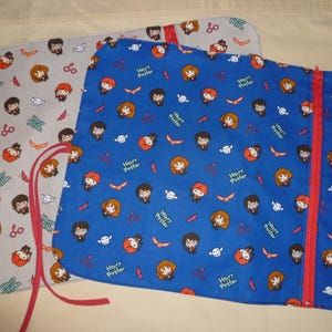 May include: Two fabric zippered pouches with a Harry Potter theme. The larger pouch is blue with a white background and features a repeating pattern of Harry Potter characters. The smaller pouch is grey with a white background and features a repeating pattern of Harry Potter characters. Both pouches have red zipper pulls.