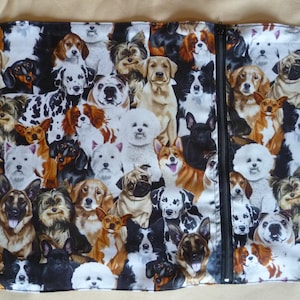 May include: A white zippered pouch with a colourful print of various dog breeds. The print features a variety of dog breeds, including a pug, a bulldog, a golden retriever, and a dachshund.