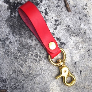 May include: A red leather key chain with a gold metal clasp.