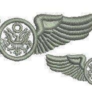 May include: Two embroidered silver-colored pilot wings. The wings are detailed with feather patterns and surround a circular emblem featuring the United States coat of arms. One set is larger than the other.