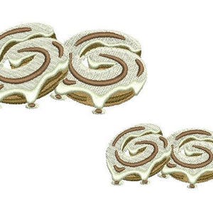 Puede incluir: Dos juegos de rollos de canela con glaseado blanco. Los rollos están apilados uno encima del otro y tienen un patrón de espiral.
