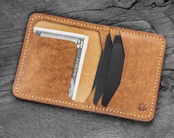 Puede incluir: Una cartera de cuero marrón con un compartimento para billetes y múltiples ranuras para tarjetas. La cartera tiene un borde cosido y un pequeño logotipo de cabeza de toro en la parte delantera.
