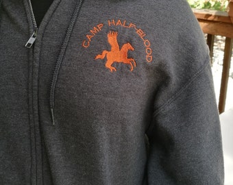 May include: A grey zipped hoodie with an orange embroidered logo that says "Camp Half-Blood" with a winged horse design.
