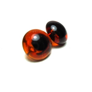 May include: Two brown glass eyes with black pupils, commonly used for craft projects.