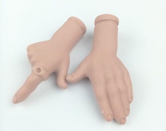 May include: Two pale pink, articulated hands, one pointing and the other open. The pointing hand has a ring on the index finger. The hands are positioned against a white background.