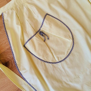 Vintage 1970 | pale yellow cotton kitchen apron with pocket and black and white piping