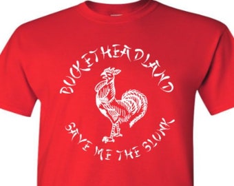 May include: Red t-shirt with a white graphic of a rooster and the text "Bucketheadland Save Me The Slunk"
