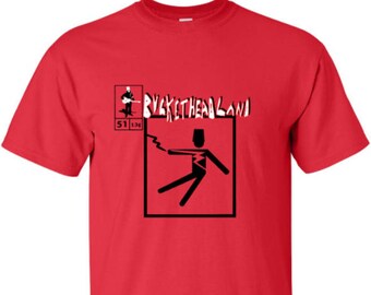 May include: Red t-shirt with a black and white graphic of a stick figure being electrocuted. The text "Buckethead Land" is printed in white above the graphic. The numbers "51 134" are printed in white below the graphic.