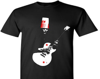 May include: Black t-shirt with a white silhouette of a person wearing a red and white bucket hat and playing a white electric guitar.