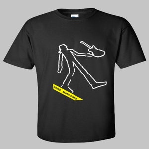 May include: Black t-shirt with a white outline of a person holding a guitar. The outline is surrounded by yellow tape with the text "Crime Slink Scene".