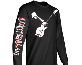 May include: Black long-sleeve t-shirt with a white silhouette of a person wearing a bucket hat and playing a guitar. The left sleeve has the text "BUCKETHEADLAND" in red and white.