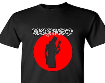 May include: Black t-shirt with a red circle and a white silhouette of a person wearing a bucket on their head and holding a guitar. The text "BUCKETHEAD" is written in white above the circle.