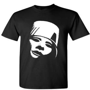 May include: Black t-shirt with a white graphic of a person's face wearing a hat. The face is stylized and has a simple design.