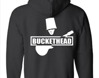 May include: Black zip-up hoodie with a white graphic of a person wearing a bucket on their head playing a guitar. The graphic also includes the text "BUCKETHEAD".
