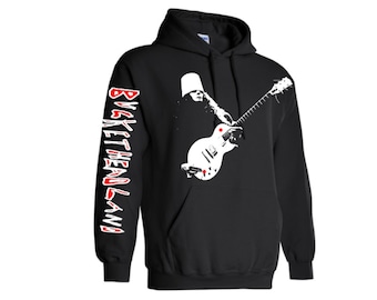 May include: Black hooded sweatshirt with a white graphic of a person wearing a bucket hat and playing a guitar. The text "BUCKETHEADLAND" is printed in white and red on the sleeve.