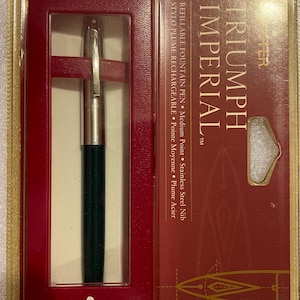 May include: A black and silver Triumph Imperial refillable fountain pen with a medium point stainless steel nib. The pen is in a red and gold box with the brand name "Sheaffer" printed on the bottom.