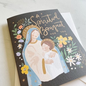 May include: A black card with a gold foiled design featuring a painting of Mary and Jesus. The card has the text "A Spiritual Bouquet For You" in gold foil.