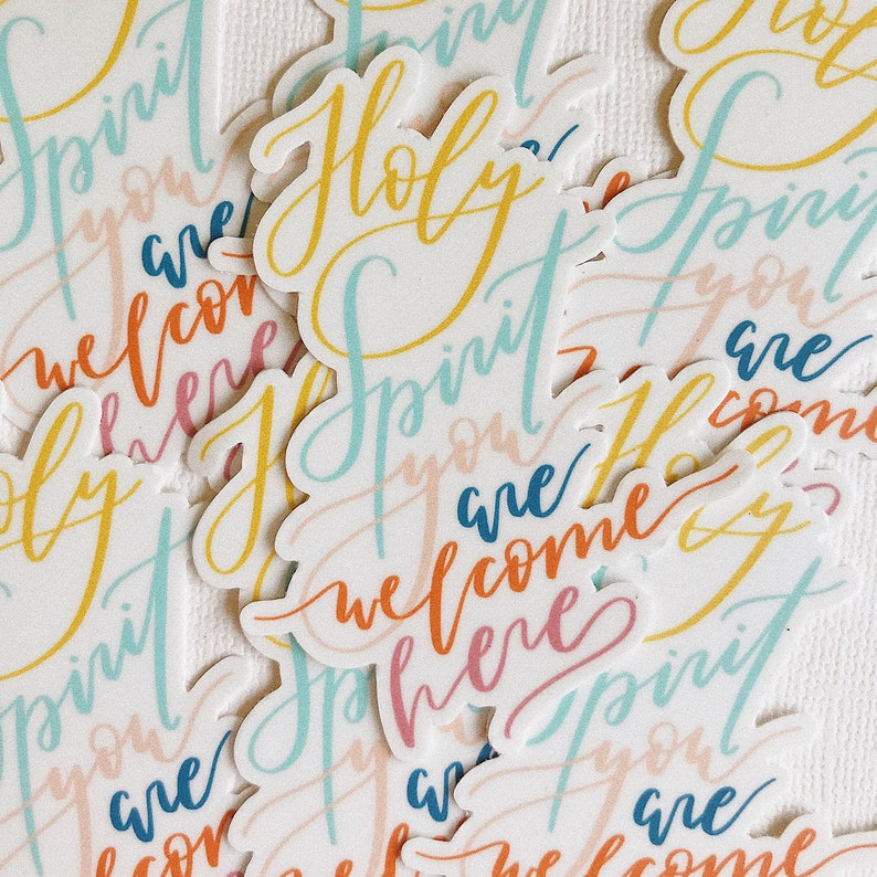K&ouml;nnte beinhalten: Eine Sammlung bunter Aufkleber mit dem Spruch "Holy Spirit you are welcome here", geschrieben in verschiedenen Schriftarten und Farben. Die Aufkleber befinden sich auf einem wei&szlig;en Hintergrund.