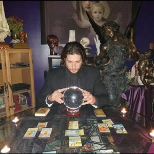 Psychic Derrek performing a tarot card reading at a candlelit altar table with crystals, offering a written PDF report digital download.