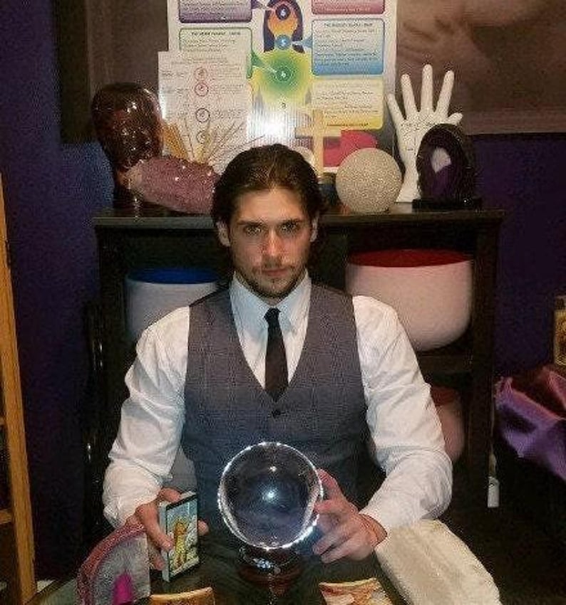 Psychic reader Derrek channeling intuitive guidance over a spread of tarot cards and glowing crystals for a fast same-day written report in PDF format.